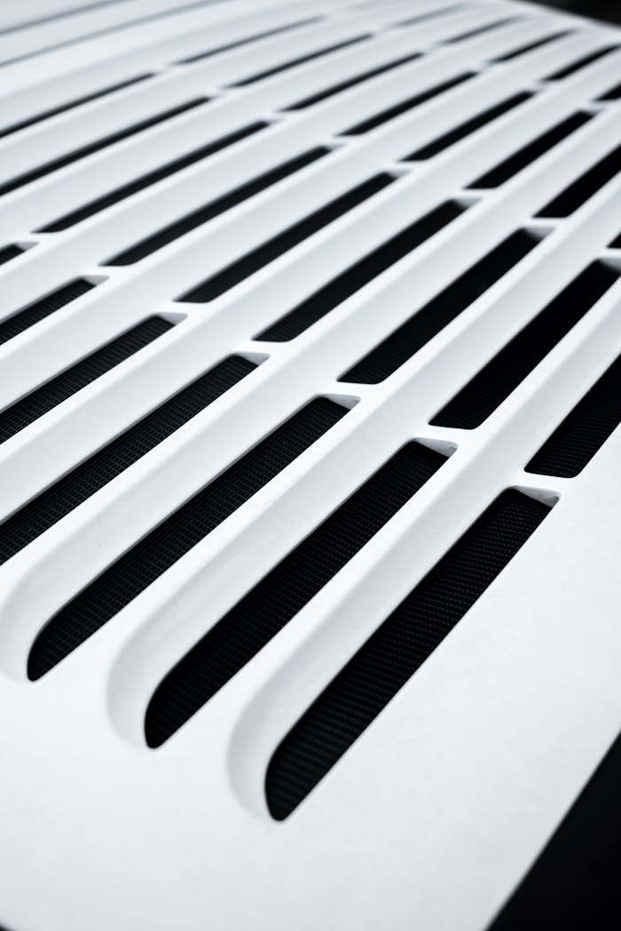 Close-up of a white vent with a modern pattern, highlighting sleek design elements.
